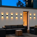 Arandela solar LED instalada em parede externa com efeito de iluminação para cima e para baixo, ideal para jardins, fachadas, muros e varandas.