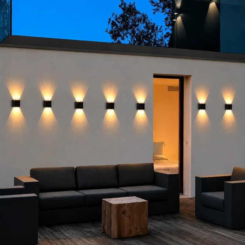 Arandela solar LED instalada em parede externa com efeito de iluminação para cima e para baixo, ideal para jardins, fachadas, muros e varandas.