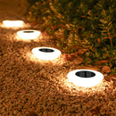 Luminárias solares LED instaladas em caminho de jardim iluminando área externa durante a noite com luz quente e elegante.